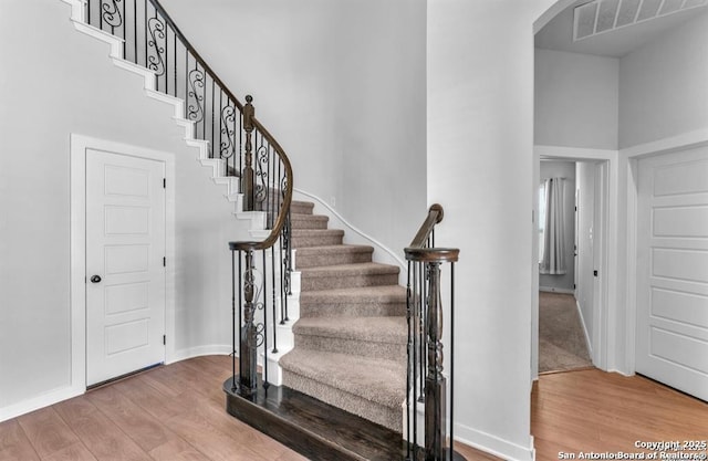 2818 Tortuga Verde, San Antonio, TX 78245 - stairs with wood finished floors, arched walkways, baseboards, and a towering ceiling