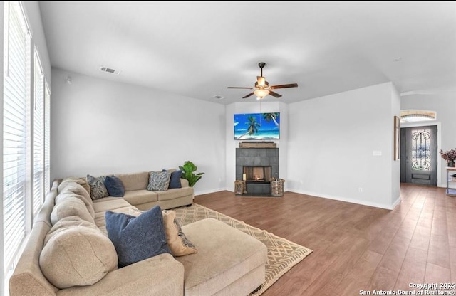 2818 Tortuga Verde, San Antonio, TX 78245 - living room featuring wood finished floors, a ceiling fan, a tile fireplace, and baseboards