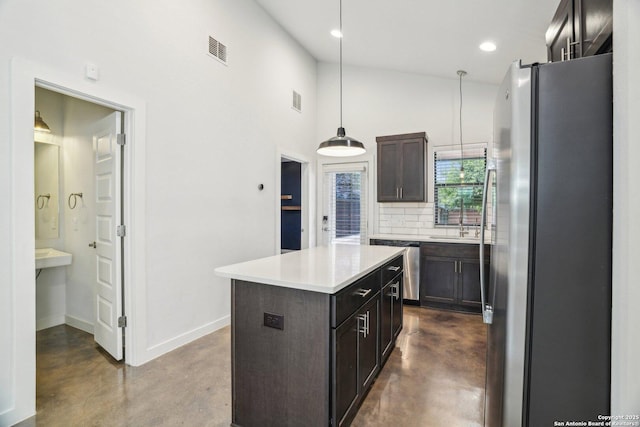 1130 N Olive St, San Antonio, TX 78202 - kitchen with stainless steel appliances, finished concrete floors, tasteful backsplash, light countertops, and a kitchen island