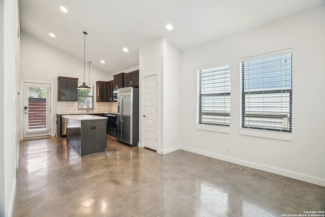 1130 N Olive St, San Antonio, TX 78202 - kitchen featuring stainless steel appliances, finished concrete floors, a center island, backsplash, and dark brown cabinetry