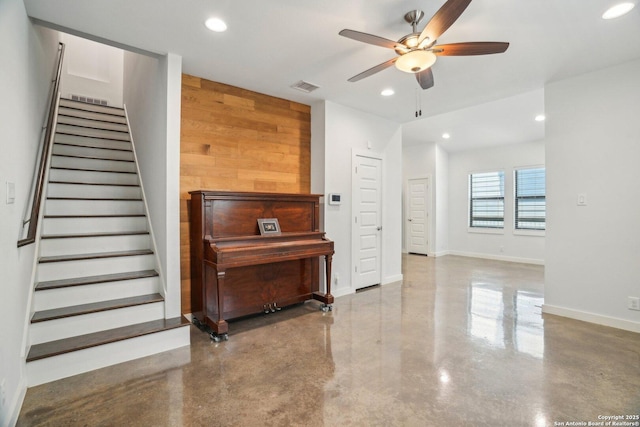 1130 N Olive St, San Antonio, TX 78202 - living area featuring concrete flooring, a ceiling fan, wooden walls, recessed lighting, and stairway