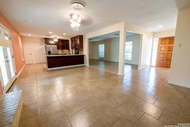 902 Newhall, Beeville, TX 78102 - unfurnished living room featuring ceiling fan, baseboards, recessed lighting, and a textured ceiling