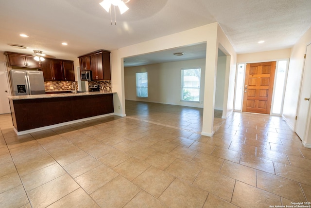 902 Newhall, Beeville, TX 78102 - kitchen with stainless steel appliances, open floor plan, backsplash, a peninsula, and dark brown cabinetry