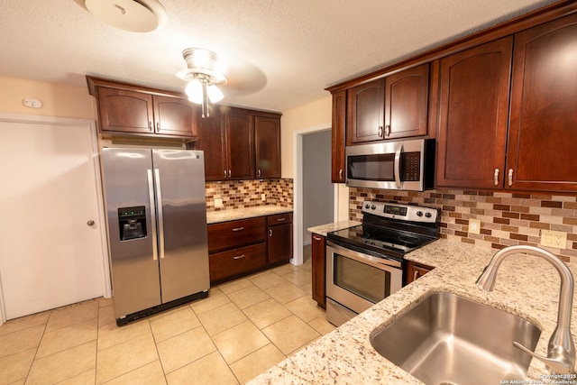 902 Newhall, Beeville, TX 78102 - kitchen featuring stainless steel appliances, a sink, light stone countertops, backsplash, and light tile patterned floors