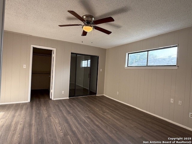 130 Nedrub Dr, San Antonio, TX 78223 - unfurnished bedroom featuring dark wood-style flooring, multiple windows, a textured ceiling, and baseboards