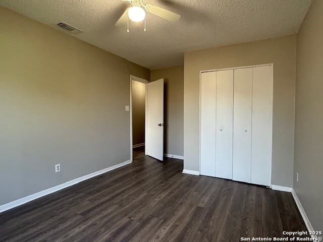 130 Nedrub Dr, San Antonio, TX 78223 - unfurnished bedroom with dark wood finished floors, a textured ceiling, baseboards, a closet, and a ceiling fan