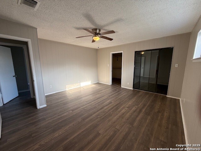 130 Nedrub Dr, San Antonio, TX 78223 - unfurnished room with dark wood-style flooring, ceiling fan, baseboards, and a textured ceiling