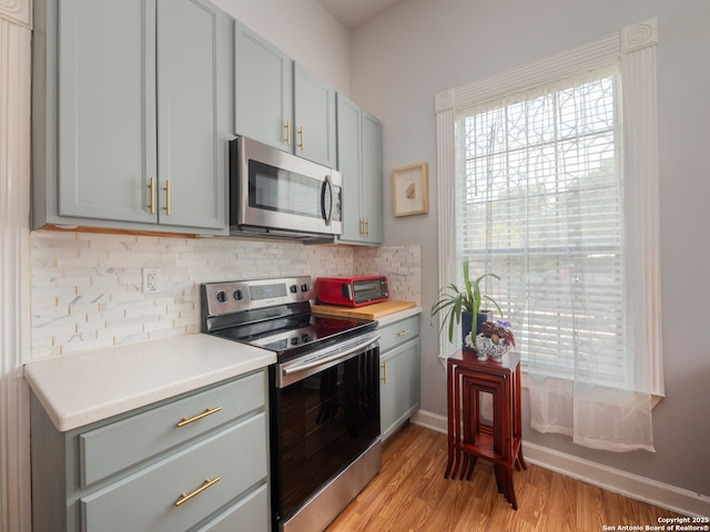 2275 Huber Rd, Seguin, TX 78155 - kitchen featuring stainless steel appliances, healthy amount of natural light, light wood finished floors, and decorative backsplash