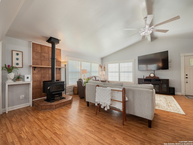 2275 Huber Rd, Seguin, TX 78155 - living room featuring a wood stove, light wood-style flooring, a ceiling fan, and baseboards