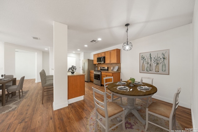 10911 Shoo Fly Trl, San Antonio, TX 78245 - dining area featuring dark wood finished floors, baseboards, and recessed lighting