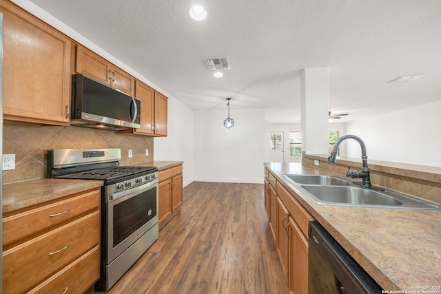 10911 Shoo Fly Trl, San Antonio, TX 78245 - kitchen with stainless steel appliances, a sink, dark wood-type flooring, decorative backsplash, and recessed lighting