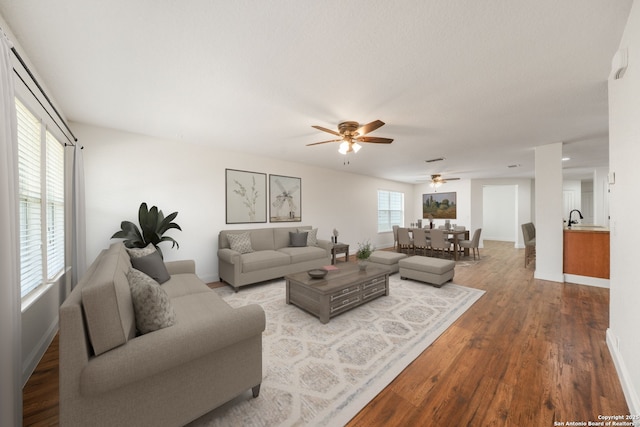 10911 Shoo Fly Trl, San Antonio, TX 78245 - living area featuring wood finished floors, a ceiling fan, and baseboards