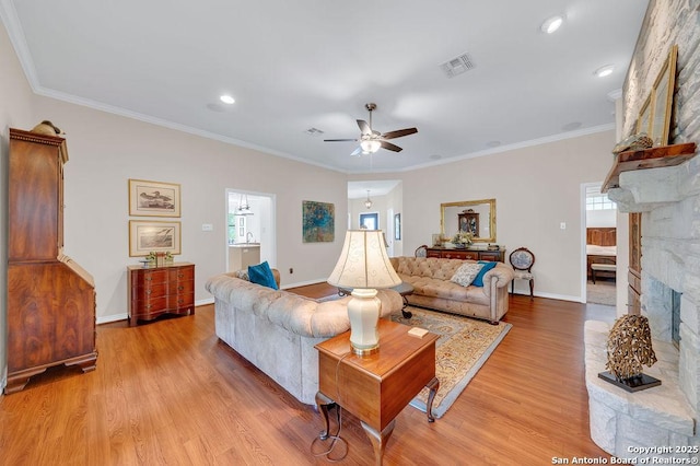1804 Athens Ave, Kerrville, TX 78028 - living room featuring ceiling fan, a large fireplace, light wood-style flooring, baseboards, and ornamental molding