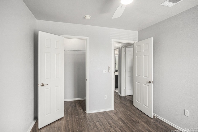 7027 Heathers Way, San Antonio, TX 78227 - unfurnished bedroom with dark wood-style flooring, a closet, baseboards, and a walk in closet