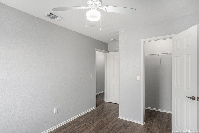 7027 Heathers Way, San Antonio, TX 78227 - unfurnished bedroom with dark wood-type flooring, a walk in closet, a closet, baseboards, and a ceiling fan