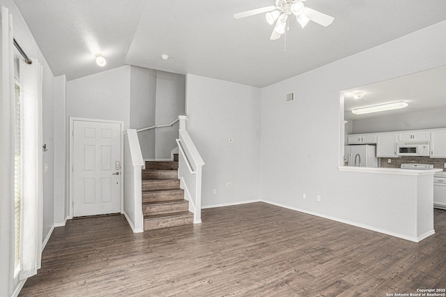 7027 Heathers Way, San Antonio, TX 78227 - unfurnished living room with ceiling fan, vaulted ceiling, stairway, dark wood-style floors, and baseboards