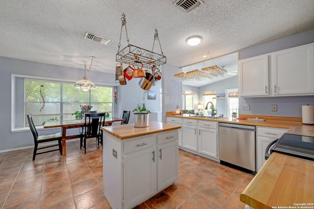 3734 Colter, San Antonio, TX 78247 - kitchen with dishwasher, butcher block countertops, a sink, a textured ceiling, and white cabinetry