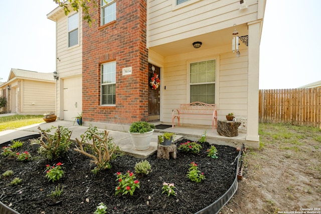 5634 Forest Cyn, San Antonio, TX 78252 - view of exterior entry featuring an attached garage, brick siding, driveway, and covered porch