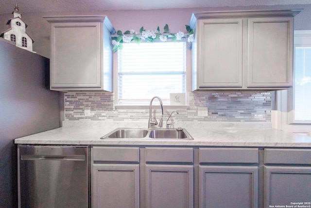 5634 Forest Cyn, San Antonio, TX 78252 - kitchen with stainless steel dishwasher, a sink, gray cabinetry, tasteful backsplash, and light stone countertops