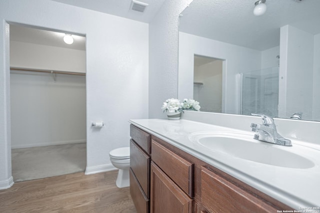 5634 Forest Cyn, San Antonio, TX 78252 - full bathroom featuring vanity, a walk in closet, toilet, a shower, and wood finished floors