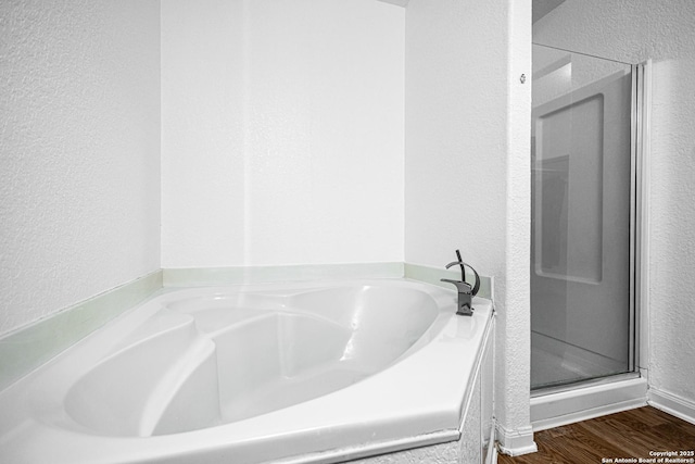 5634 Forest Cyn, San Antonio, TX 78252 - bathroom featuring a bath, a stall shower, a textured wall, and wood finished floors