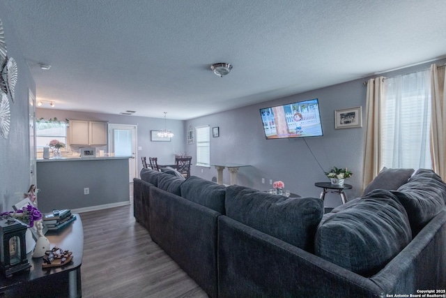 5634 Forest Cyn, San Antonio, TX 78252 - living room featuring a textured ceiling, wood finished floors, a chandelier, plenty of natural light, and baseboards