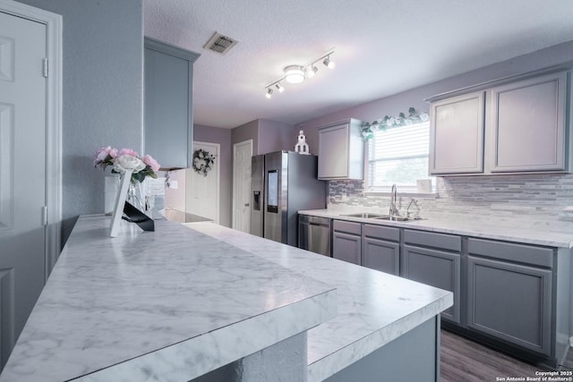 5634 Forest Cyn, San Antonio, TX 78252 - kitchen with a sink, appliances with stainless steel finishes, gray cabinets, decorative backsplash, and light countertops