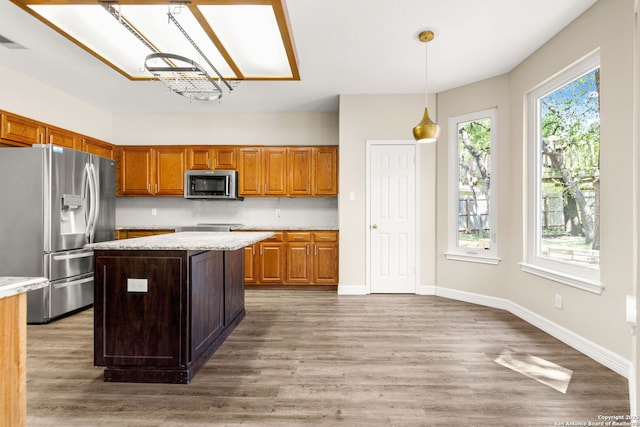 122 Kettle Cv, Universal City, TX 78148 - kitchen featuring stainless steel appliances, backsplash, light wood-style flooring, a kitchen island, and decorative light fixtures