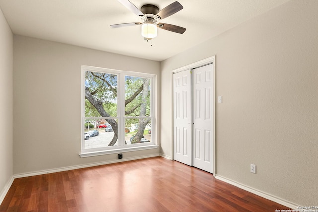 122 Kettle Cv, Universal City, TX 78148 - unfurnished bedroom with wood finished floors, baseboards, a closet, and a ceiling fan