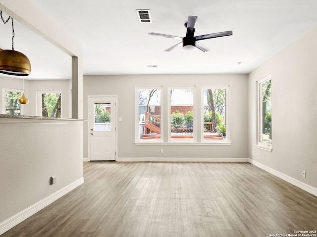 122 Kettle Cv, Universal City, TX 78148 - unfurnished living room with wood finished floors, baseboards, plenty of natural light, and a ceiling fan
