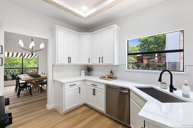 959 Lightstone Dr, San Antonio, TX 78258 - kitchen with dishwasher, a sink, light countertops, light wood finished floors, and decorative backsplash