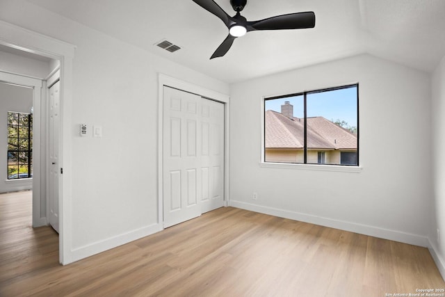 959 Lightstone Dr, San Antonio, TX 78258 - unfurnished bedroom with light wood-style floors, multiple windows, baseboards, a closet, and vaulted ceiling