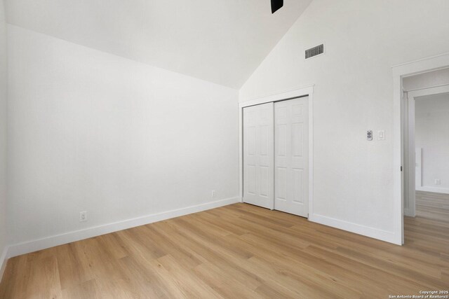 959 Lightstone Dr, San Antonio, TX 78258 - unfurnished bedroom with baseboards, high vaulted ceiling, light wood-style flooring, and a closet