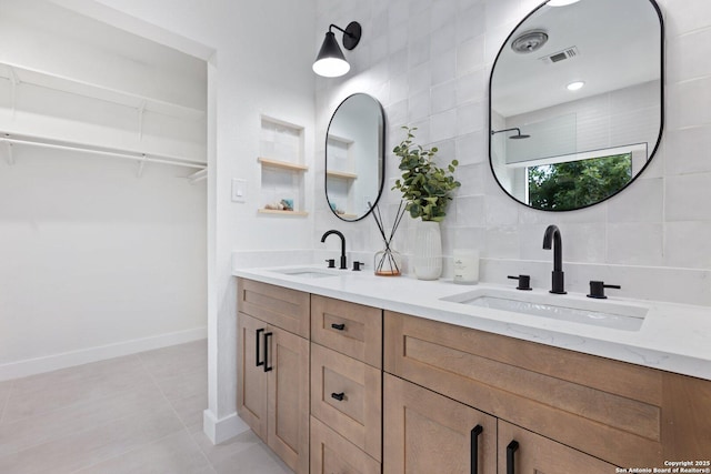 959 Lightstone Dr, San Antonio, TX 78258 - full bathroom with double vanity, a walk in closet, tile patterned flooring, tasteful backsplash, and baseboards
