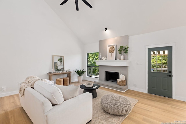 959 Lightstone Dr, San Antonio, TX 78258 - living area with high vaulted ceiling, ceiling fan, a fireplace with raised hearth, wood finished floors, and baseboards