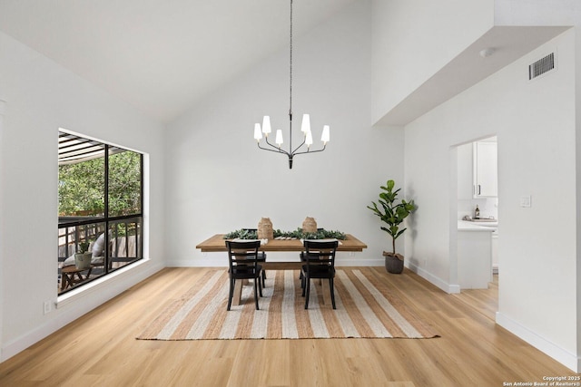 959 Lightstone Dr, San Antonio, TX 78258 - dining space featuring high vaulted ceiling, light wood-type flooring, a chandelier, and baseboards