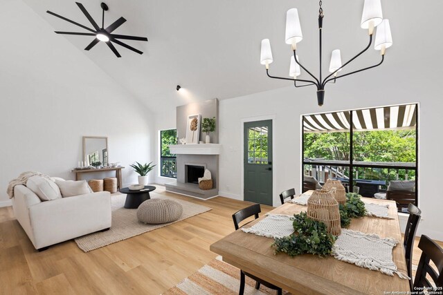 959 Lightstone Dr, San Antonio, TX 78258 - living room with high vaulted ceiling, a chandelier, wood finished floors, a fireplace with raised hearth, and baseboards