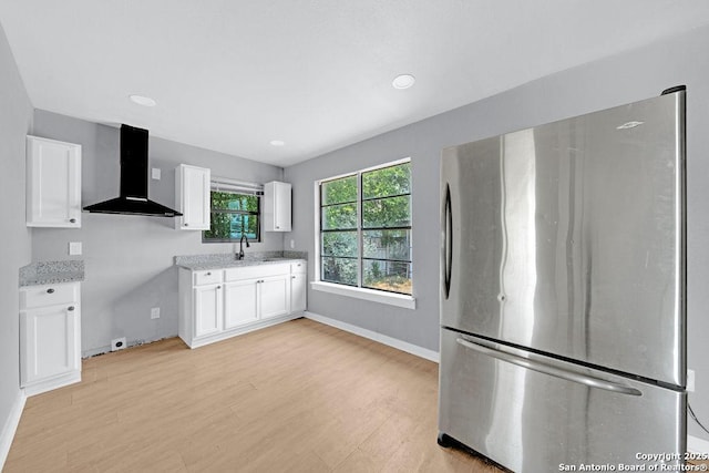139 Wichita Ct, San Antonio, TX 78225 - kitchen with freestanding refrigerator, wall chimney exhaust hood, light wood-type flooring, white cabinets, and recessed lighting