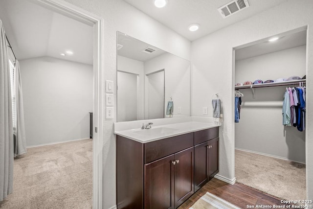 712 Monarch, Seguin, TX 78155 - bathroom with vanity, a walk in closet, wood finished floors, recessed lighting, and baseboards