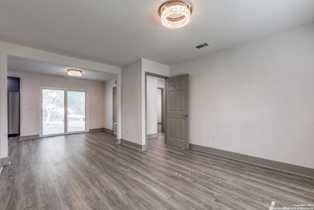 2822 Spokane, San Antonio, TX 78222 - unfurnished room with wood finished floors, baseboards, and a chandelier