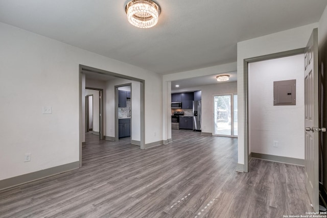 2822 Spokane, San Antonio, TX 78222 - unfurnished living room featuring electric panel, wood finished floors, and baseboards