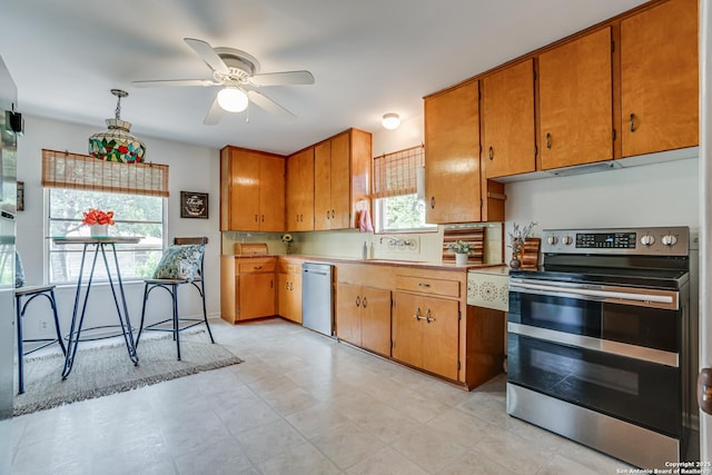 438 Cosgrove, San Antonio, TX 78210 - kitchen featuring stainless steel appliances, a ceiling fan, brown cabinets, light countertops, and a sink