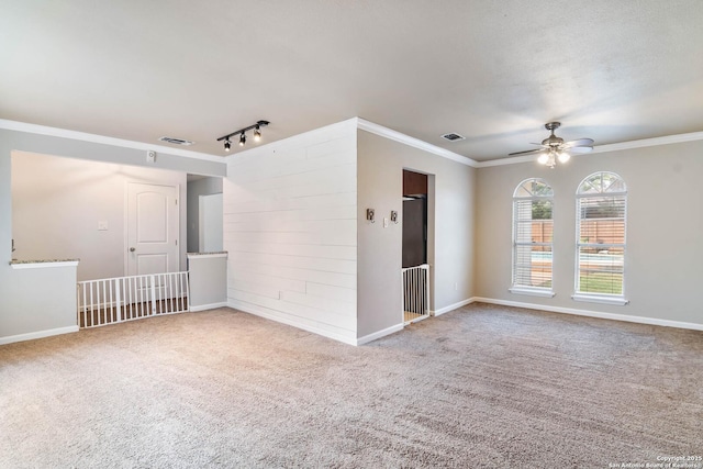 13635 Oak Breeze, Universal City, TX 78148 - spare room featuring crown molding, carpet flooring, ceiling fan, baseboards, and rail lighting