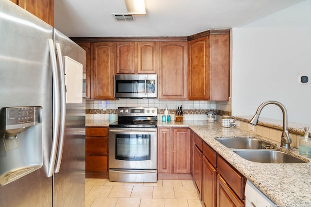 13635 Oak Breeze, Universal City, TX 78148 - kitchen with stainless steel appliances, a sink, light stone counters, light tile patterned flooring, and decorative backsplash