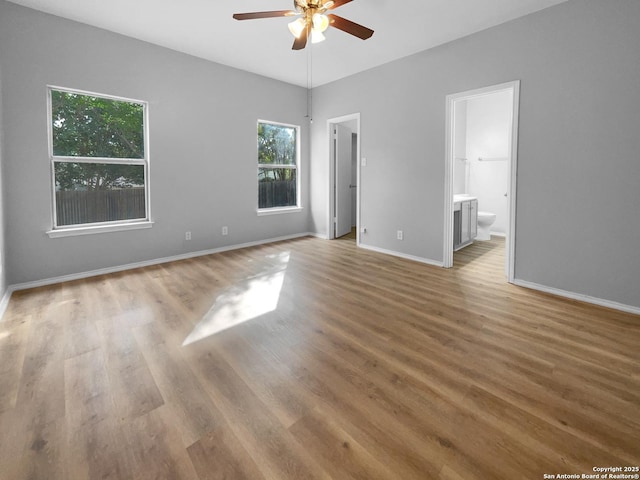 13611 Drakewood, San Antonio, TX 78247 - unfurnished bedroom featuring wood finished floors, baseboards, connected bathroom, and a ceiling fan