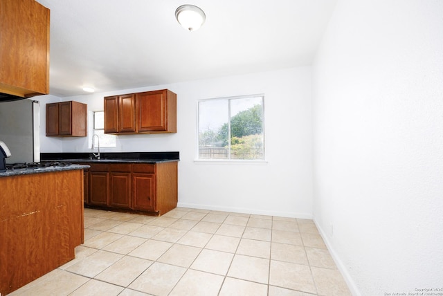 429 Aviation, Universal City, TX 78148 - kitchen featuring dark countertops, healthy amount of natural light, light tile patterned flooring, and baseboards