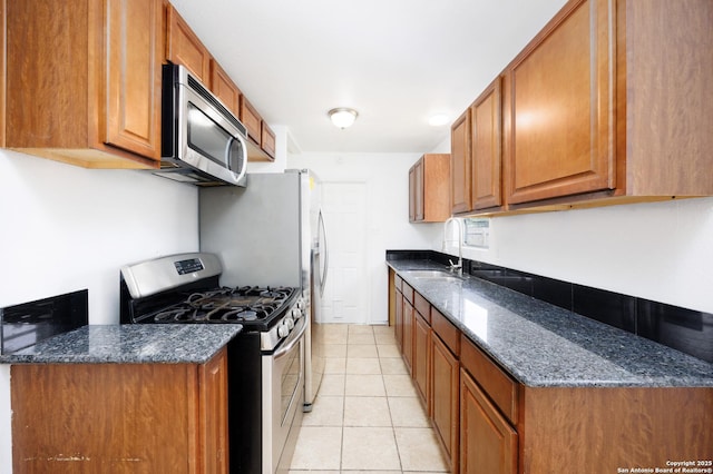 429 Aviation, Universal City, TX 78148 - kitchen featuring appliances with stainless steel finishes, a sink, light tile patterned floors, and brown cabinets