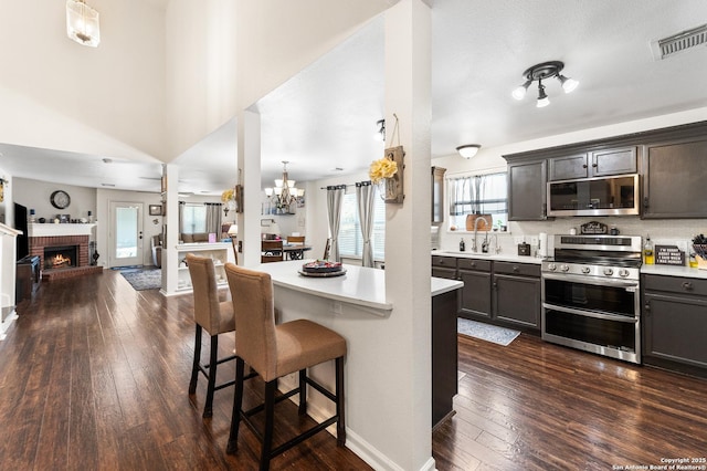 1623 Rainy Brk, Schertz, TX 78154 - kitchen with appliances with stainless steel finishes, light countertops, open floor plan, and a kitchen bar
