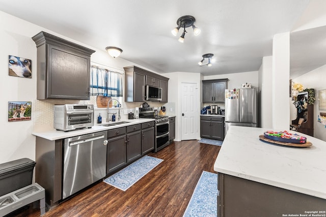 1623 Rainy Brk, Schertz, TX 78154 - kitchen with appliances with stainless steel finishes, a sink, dark wood-type flooring, decorative backsplash, and light stone counters