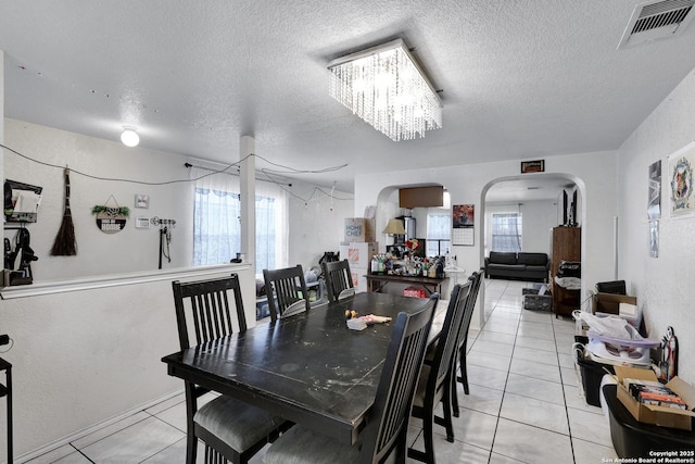 1515 Agency, San Antonio, TX 78245 - dining area featuring light tile patterned floors, a textured ceiling, arched walkways, and a chandelier
